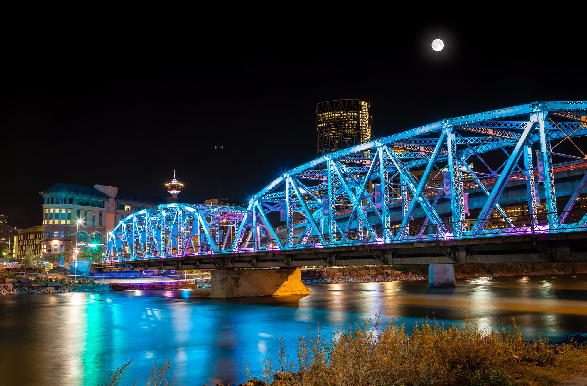 A photograph of the George C King bridge in Calgary, Alberta lit up with blue LED's at night